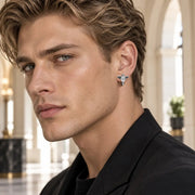 Arete Raven Cross 15 mm de acero 304L con circonia 5A, en la oreja de un modelo.