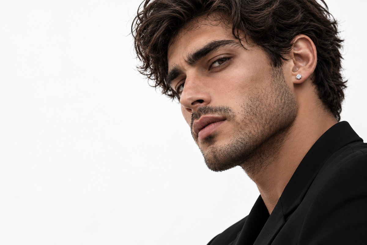 Modelo masculino con arete pequeño plateado sobre fondo blanco para Lion Luxury